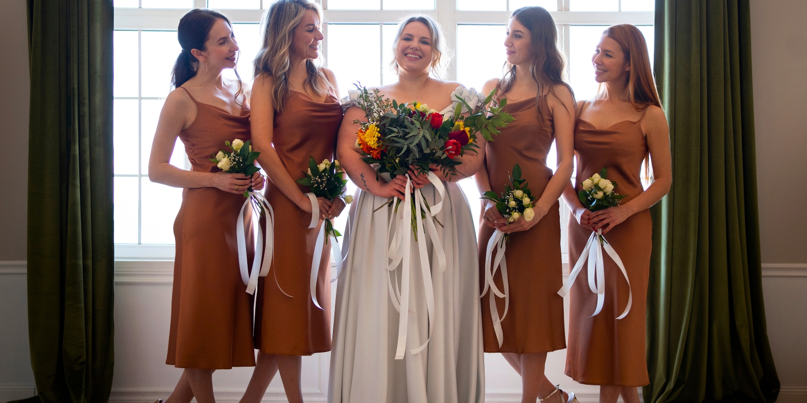 La mariée entourée de ses demoiselles d’honneur en robes terracotta.